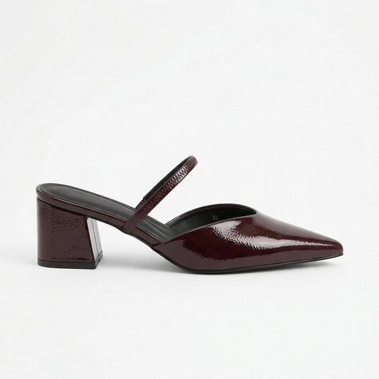 Burgundy patent leather shoe with a strap on a white background facing right